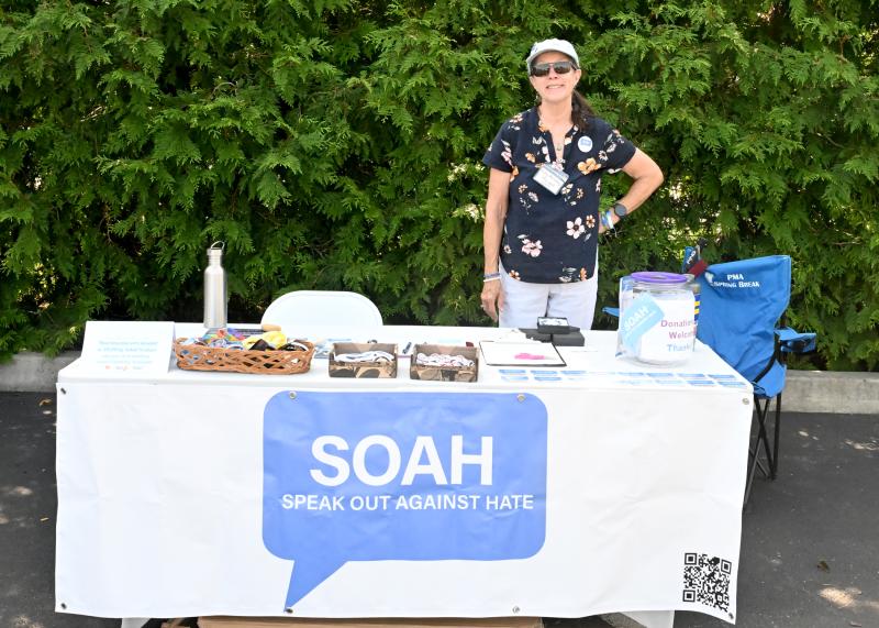 Patty Maloney, president of Speak Out Against Hate, offers information about the organization at her table.